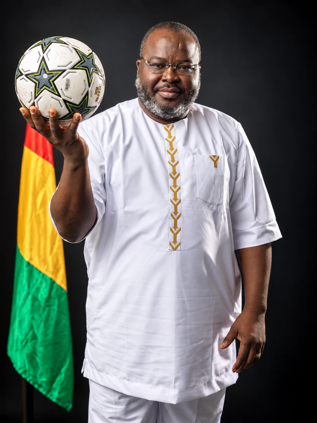 Le Dr Ibrahima Khalil KABA, ballon levé, devant le drapeau guinéen