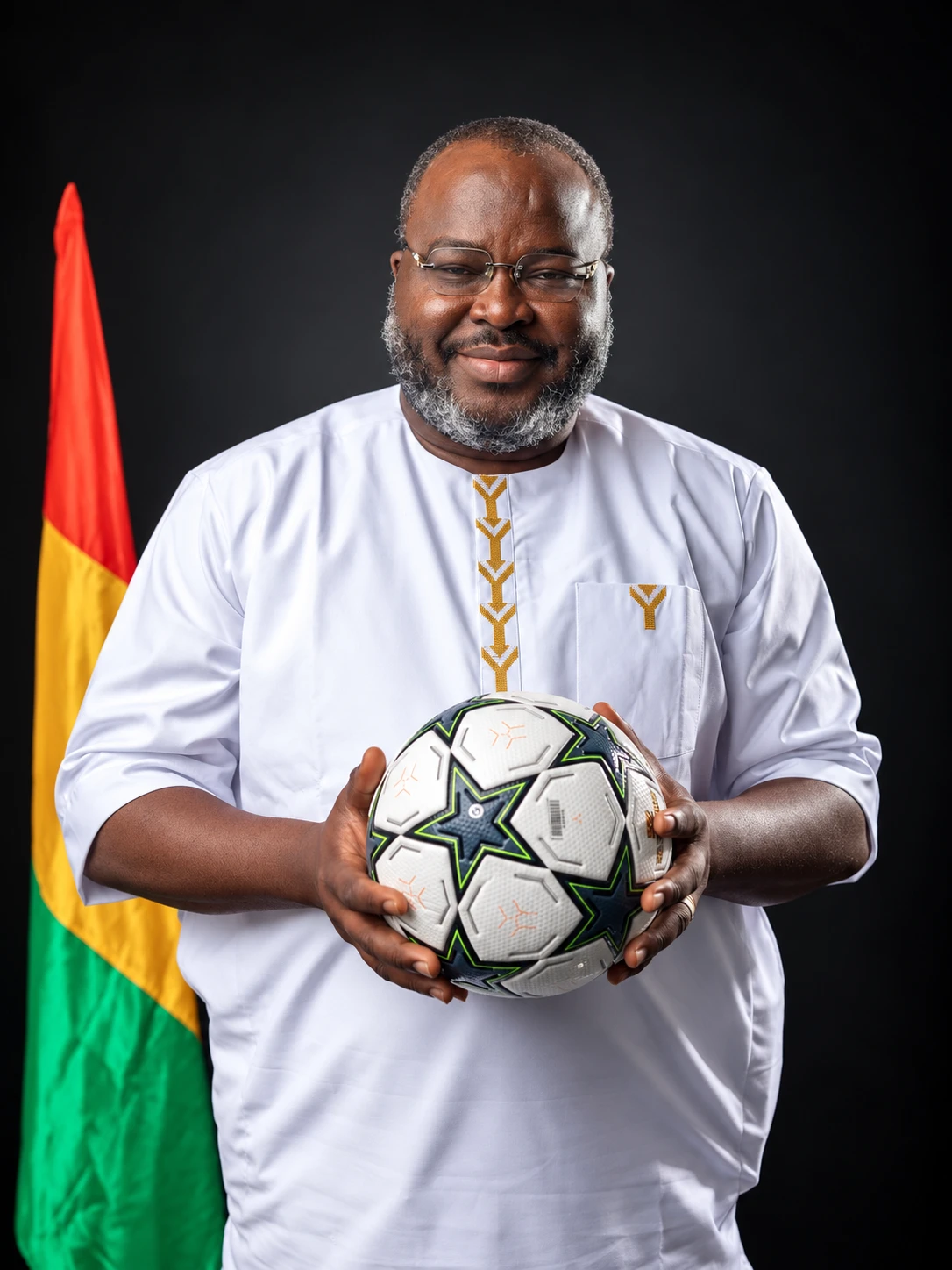 Le Dr Ibrahima Khalil KABA, un ballon entre les mains, devant le drapeau guinéen